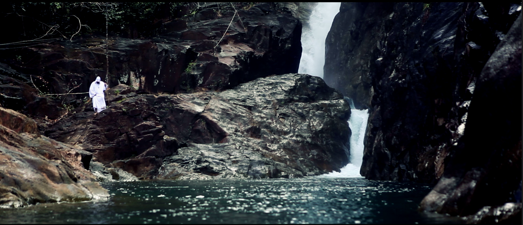 Long-lens camera frame of a waterfall and rocky landscape
